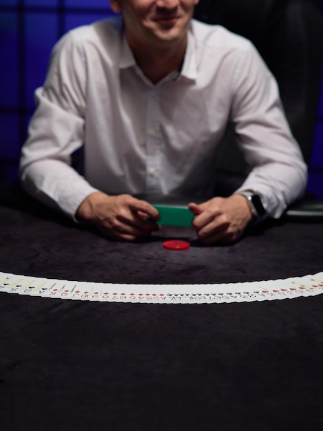 Foto el crupier o croupier baraja cartas de póquer en un casino en el fondo de una mesa de fichas