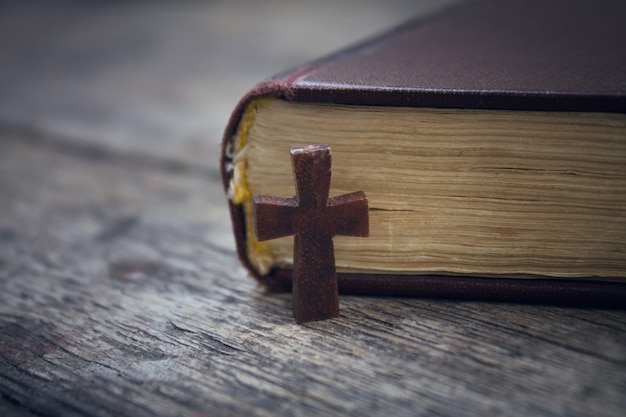 Cruz y Biblia sobre un fondo de madera.