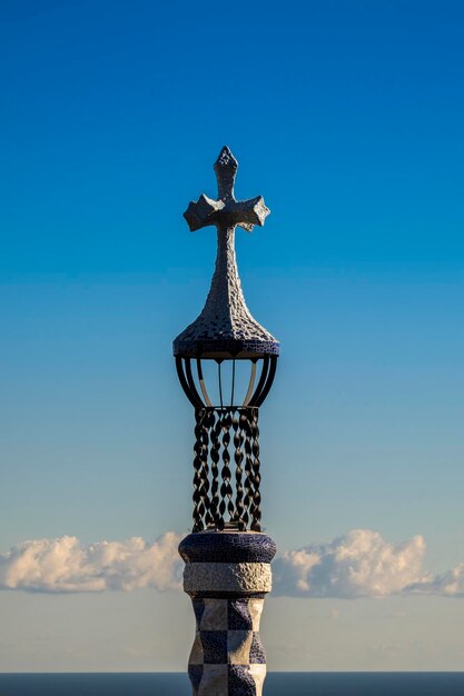 Foto cruz en la columna contra el cielo azul