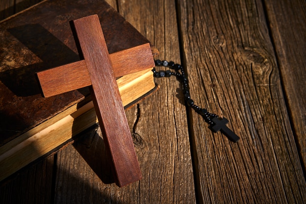 Cruz cristã na bíblia de madeira e rosário