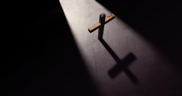 Cruz cristiana de madera esperanza fe y conceptos religiosos sombra de luz desde la puerta de apertura vista superior
