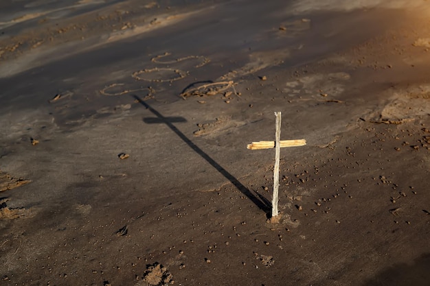 Cruz cristiana de madera en la playa detrás de la inscripción SOS