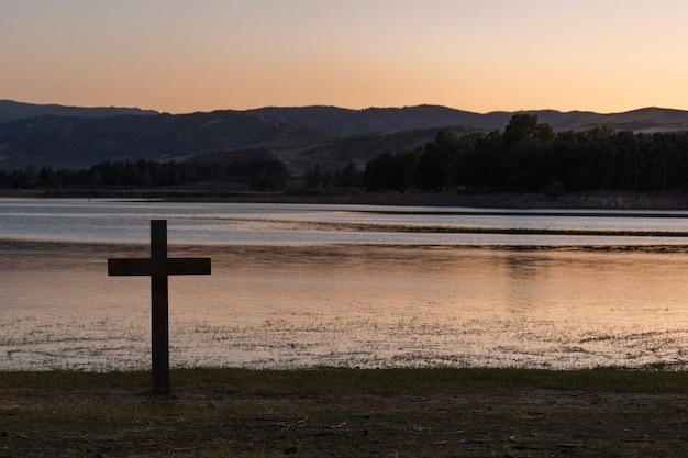 Cruz cristiana con paisaje natural.