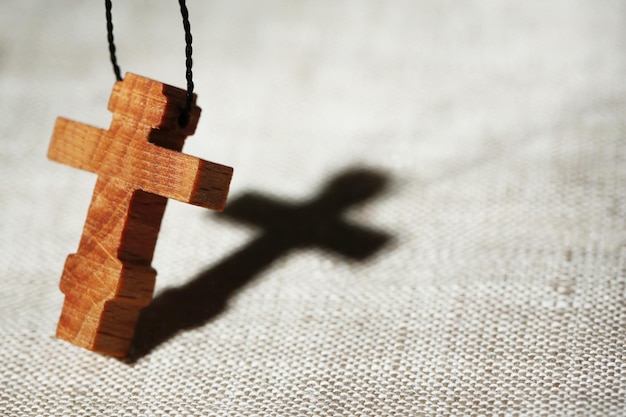 Foto cruz de madeira com sombra profunda no fundo de madeira