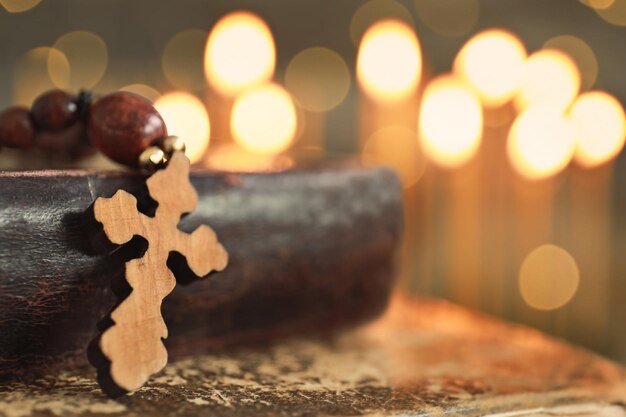 Cruz de madeira e livro contra luzes desfocadas