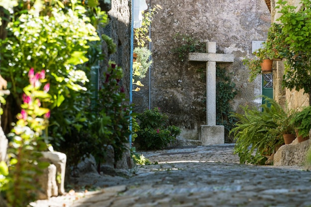 Cruz de pedra em uma rua do antigo português Monsanto vollage Portugal
