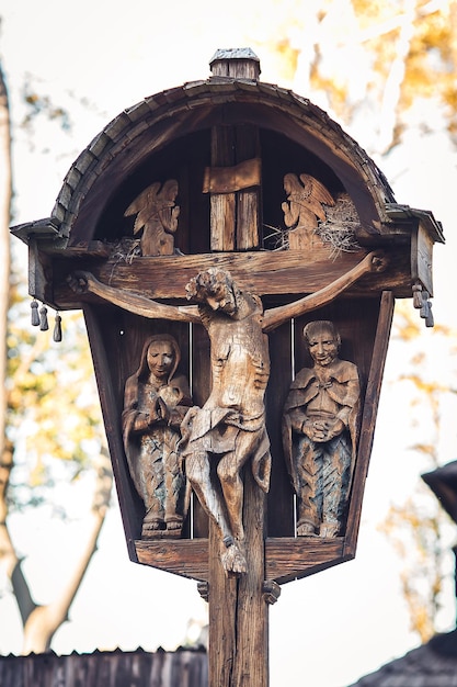 Cruz con estatua de Jesús crucificado y ángeles a los lados.