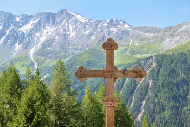 Cruz de madera frente a las montañas pico