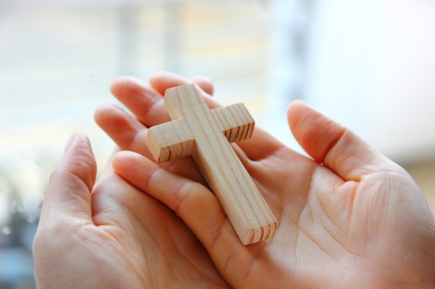 cruz de madera en mano de mujer