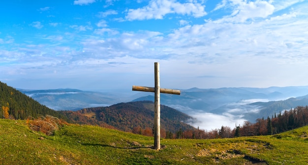 Cruz de madera en la meseta de la montaña de otoño.