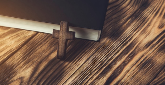 Foto cruz de madera en la santa biblia sobre mesa de madera