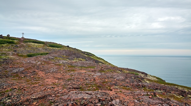 Cruz ortodoxa na costa rochosa do mar de Barents, Península de Kola, Rússia