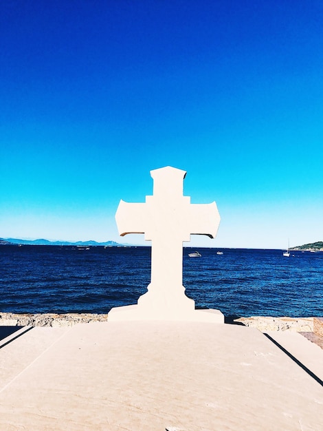 Foto cruz en la playa contra el cielo azul claro