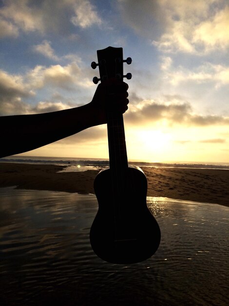 Foto cruz en la playa contra el cielo durante la puesta de sol