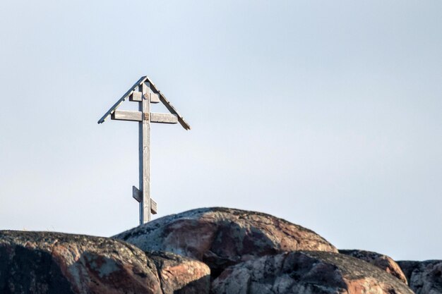 Cruz religiosa instalada en una roca cerca de la orilla del mar