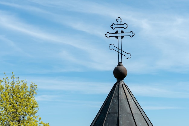 La cruz en la torre de la iglesia contra el fondo del sol y el cielo despejado en un cálido día de verano La cruz como símbolo de la fe en Dios