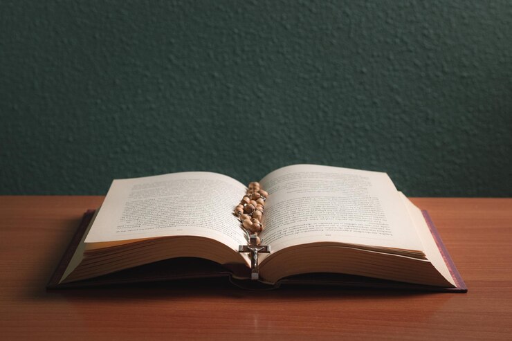 Cruza la sagrada biblia sobre una mesa de madera