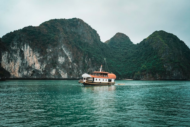 Cruzeiro entre belas rochas calcárias e praias isoladas na baía de Ha Long, patrimônio mundial da UNESCO, Vietnã