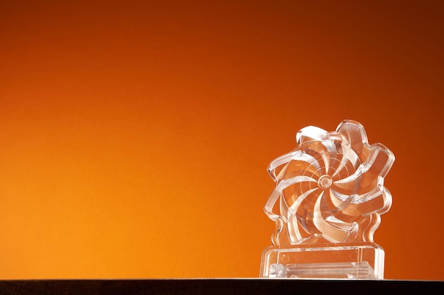 Crystal Award Trophäe vor orangefarbenem Hintergrund