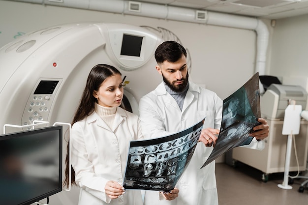 CT-Scan-Ärzte diskutieren Röntgenaufnahme der Computertomographie des Gehirns des Patienten. Computertomographie-Ärzte beraten und diskutieren Röntgenaufnahme des Patienten