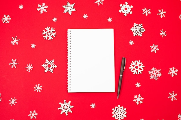 Cuaderno abierto y decoraciones navideñas en rojo. Endecha plana