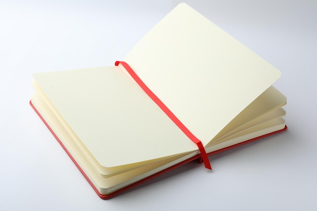 Un cuaderno abierto elegante con hojas en blanco aisladas en blanco