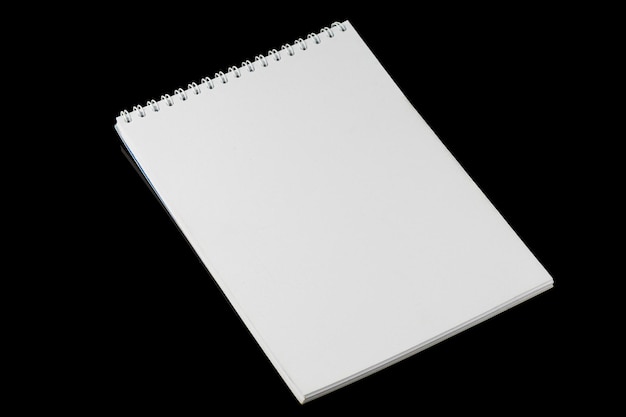 Cuaderno blanco en blanco sobre un fondo negro