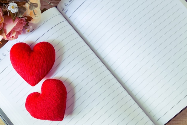 Cuaderno en blanco y corazones con flores