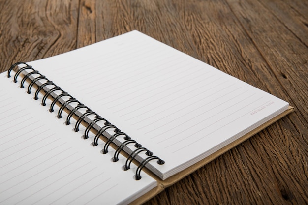 cuaderno en blanco en la mesa de madera de trabajo