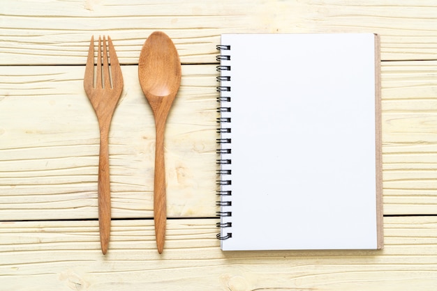 cuaderno en blanco para nota de texto sobre superficie de madera con copia sapce