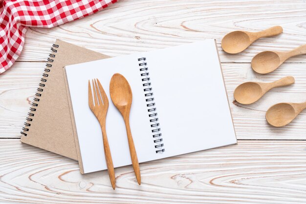 cuaderno en blanco para nota de texto sobre superficie de madera con copia sapce