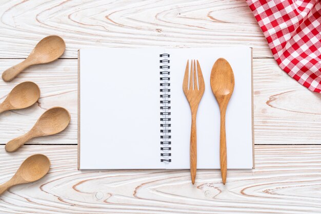 cuaderno en blanco para nota de texto sobre superficie de madera con copia sapce