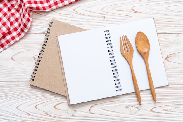 cuaderno en blanco para nota de texto sobre superficie de madera