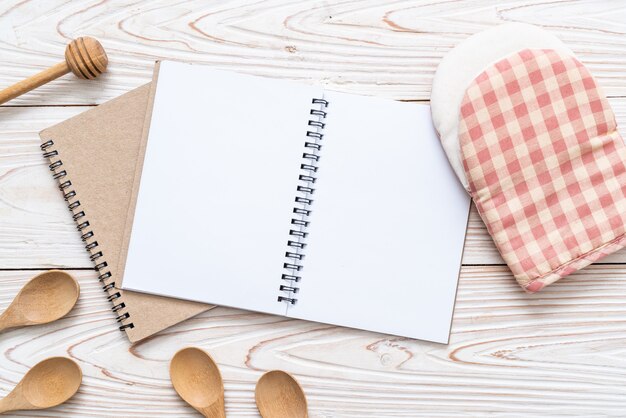 cuaderno en blanco para nota de texto sobre superficie de madera