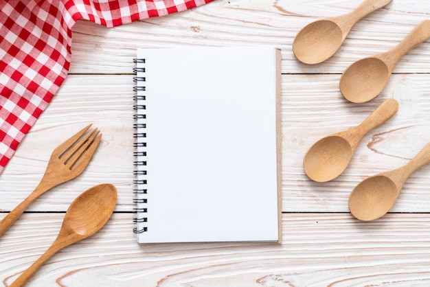 Cuaderno en blanco para nota de texto en superficie de madera con copia sapce