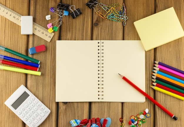 Cuaderno en blanco con papelería alrededor.