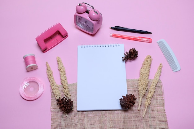 Foto cuaderno en blanco con pinecoves, weker, ponche de papel de dos agujeros