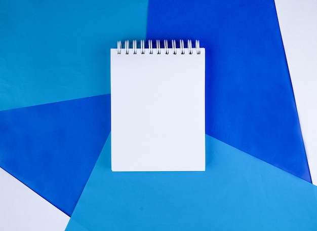 un cuaderno blanco sobre un fondo azul