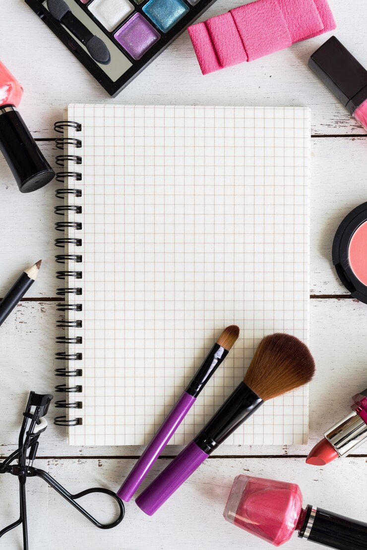 Foto cuaderno en blanco con varios productos de maquillaje y cosméticos