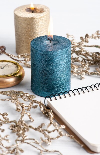 Cuaderno en blanco, velas de aroma dorado azul y juguetes de Navidad en madera rústica