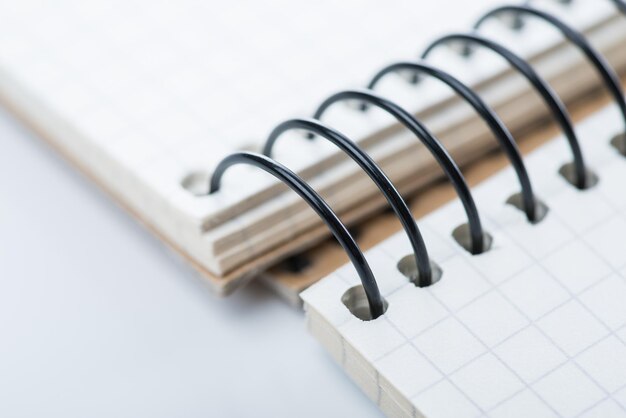 Un cuaderno de bocetos en espiral en blanco sobre la mesa blanca