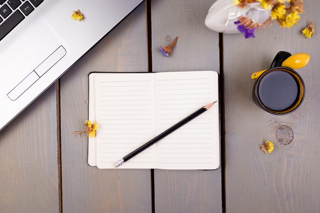 Cuaderno, café y flores para el trabajo femenino del hogar o la oficina,