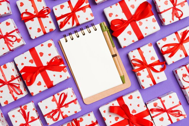 cuaderno y cajas de regalo blancas con corazones rojos