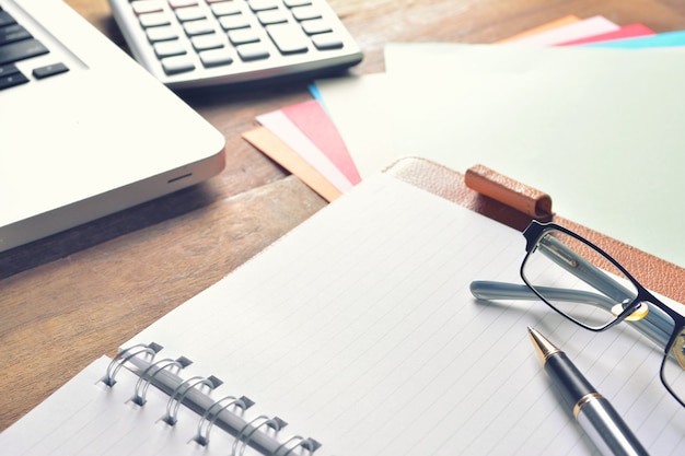 Cuaderno con calculadora, teclado y bolígrafo en la mesa