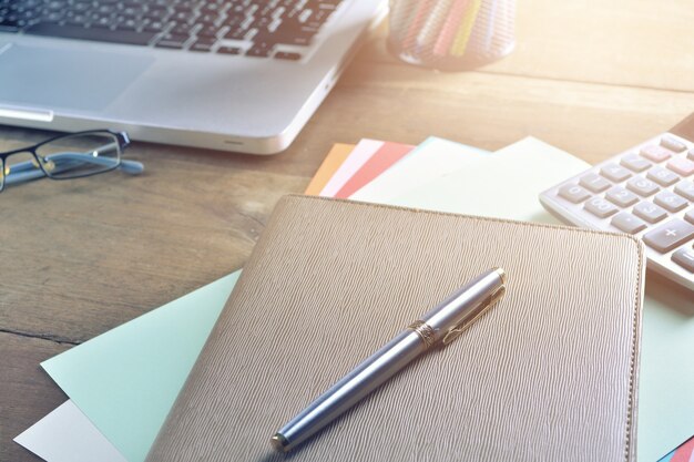 Cuaderno con calculadora, teclado y bolígrafo en la mesa