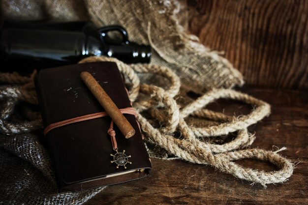 Cuaderno de cigarros y cuero sobre un fondo de madera