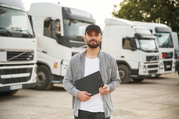 Un cuaderno de color negro en las manos Un joven camionero con ropa casual