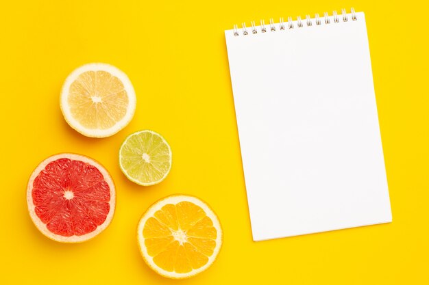 Foto cuaderno y corte tropical de cítricos, naranja y lima