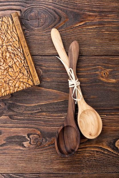 Cuaderno y cucharas de madera sobre mesa de madera