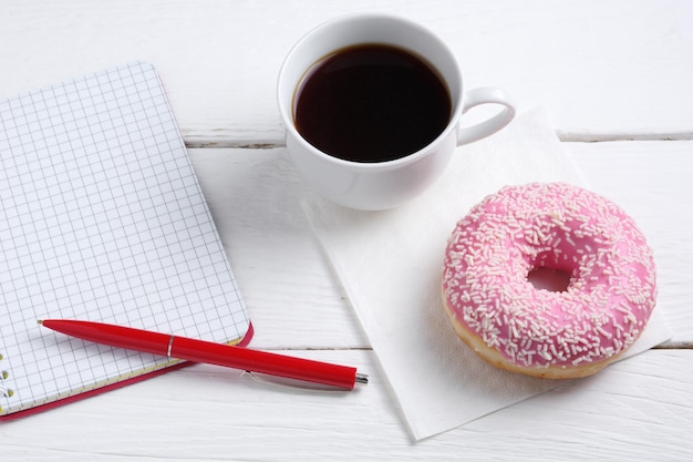 Cuaderno y donut con café.